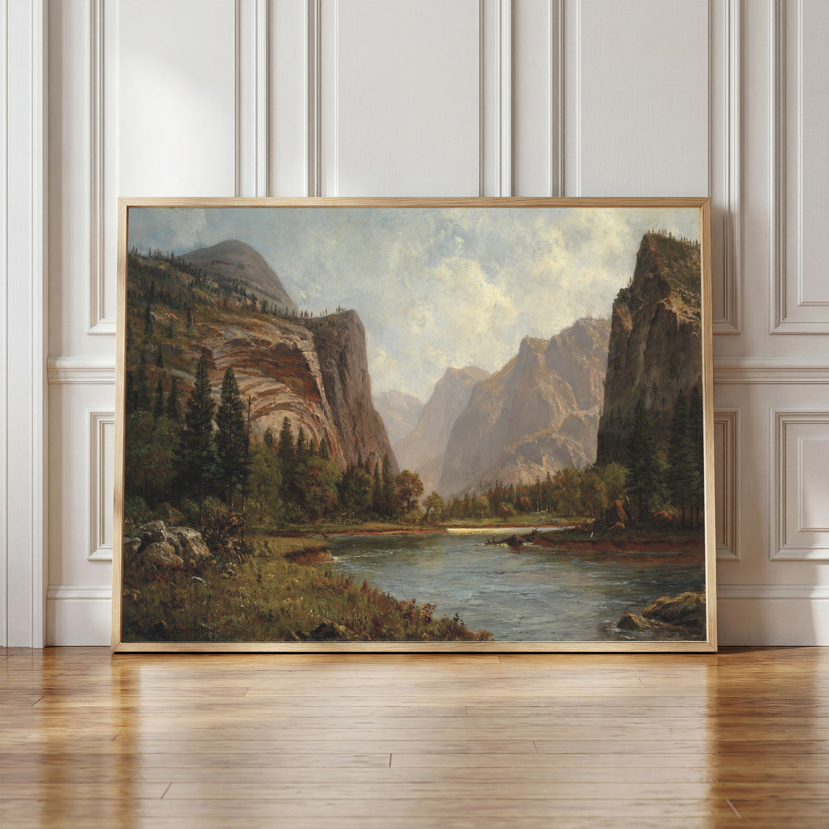 Framed art print of Gates of the Yosemite by Albert Bierstadt, in a light wood frame leaning against a panelled white wall