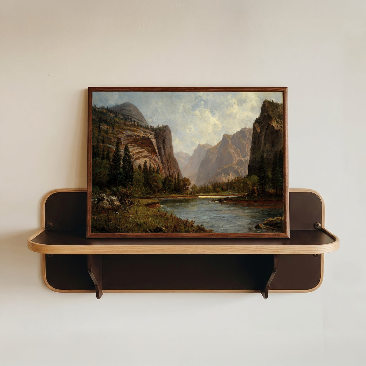 Framed art print of Gates of the Yosemite by Albert Bierstadt, in a dark wood frame resting on a wall shelf
