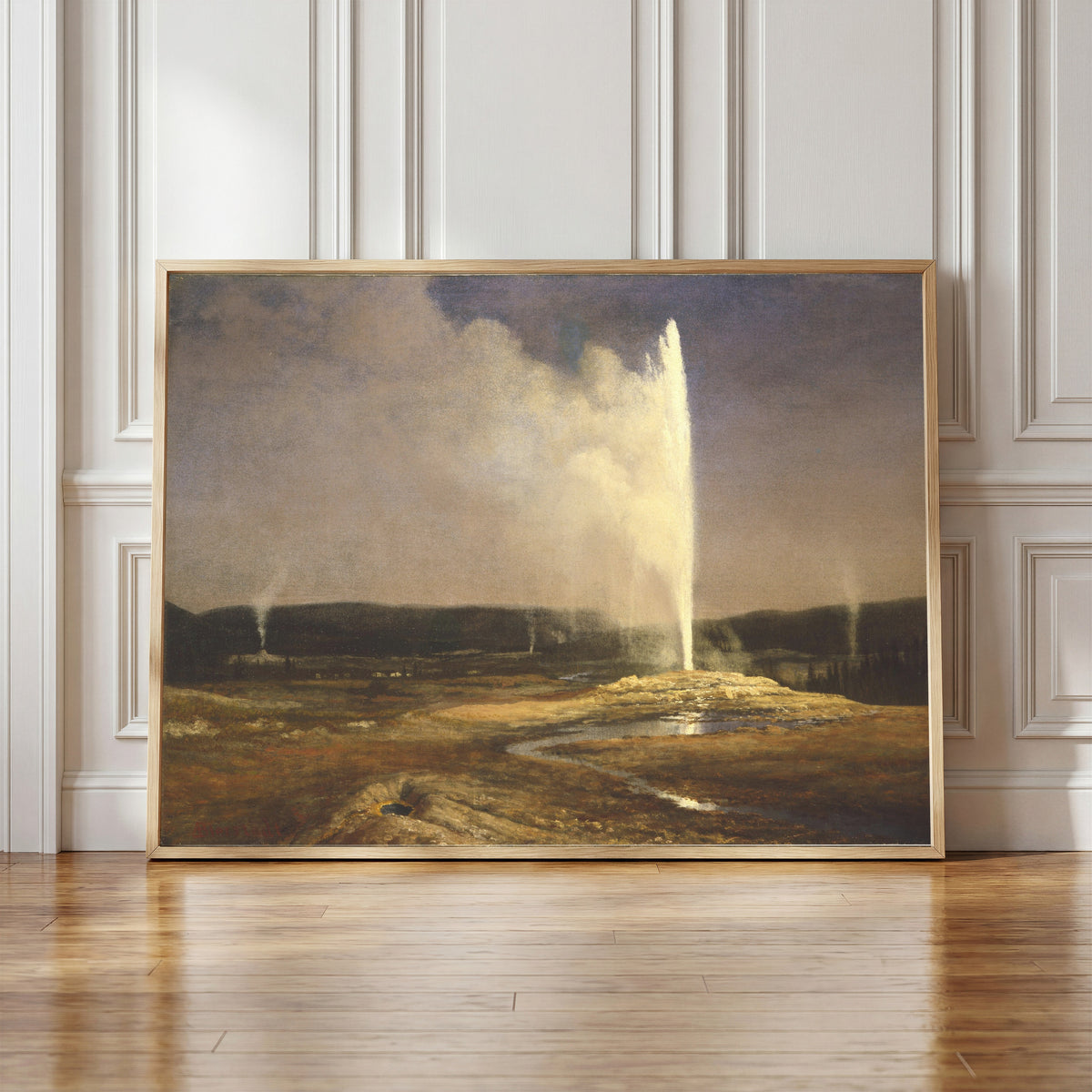 Framed art print of Geysers by Albert Bierstadt, in a light wood frame leaning against a panelled white wall