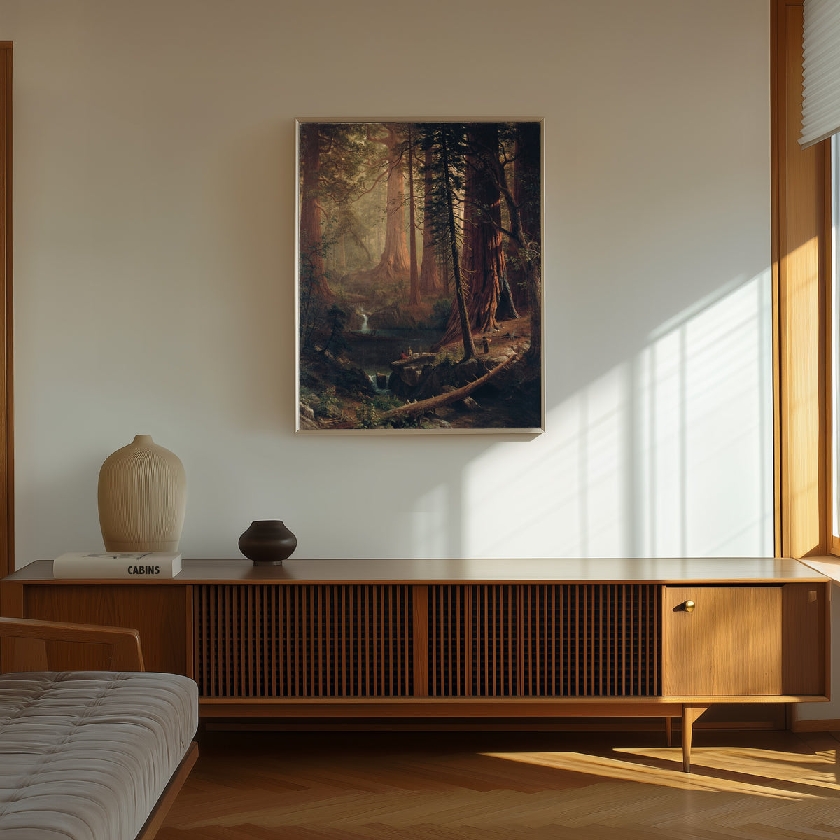 Framed art print of Giant Redwood Trees of California by Albert Bierstadt, in a thin light frame on a sunlit wall above a wooden sideboard