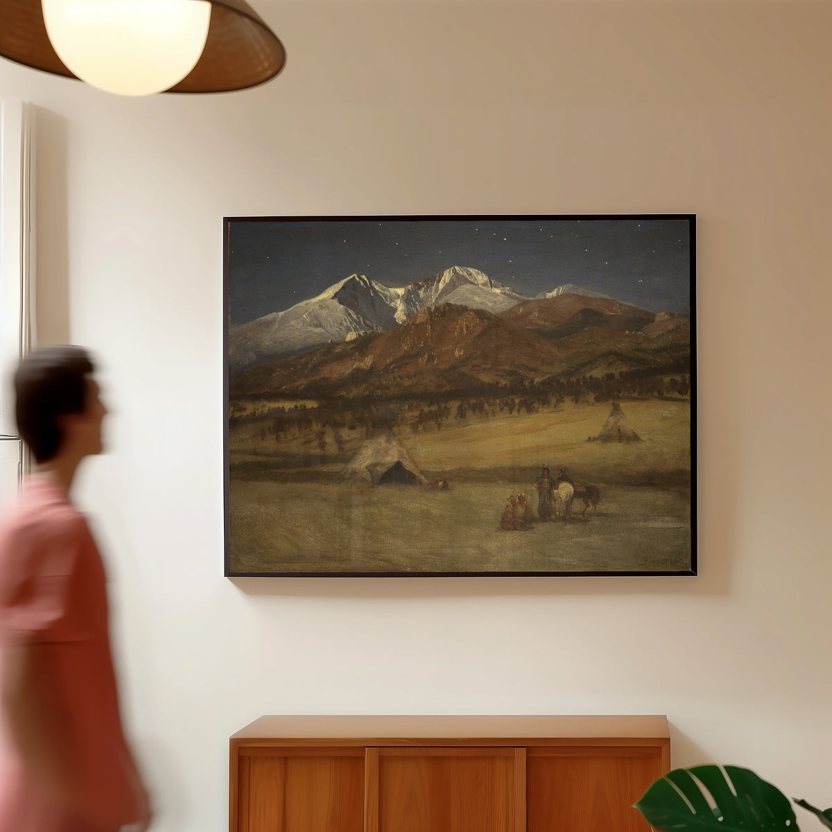 Framed art print of Indian Encampment – Evening by Albert Bierstadt, in a slim black frame on a warm wall in a sunlit room
