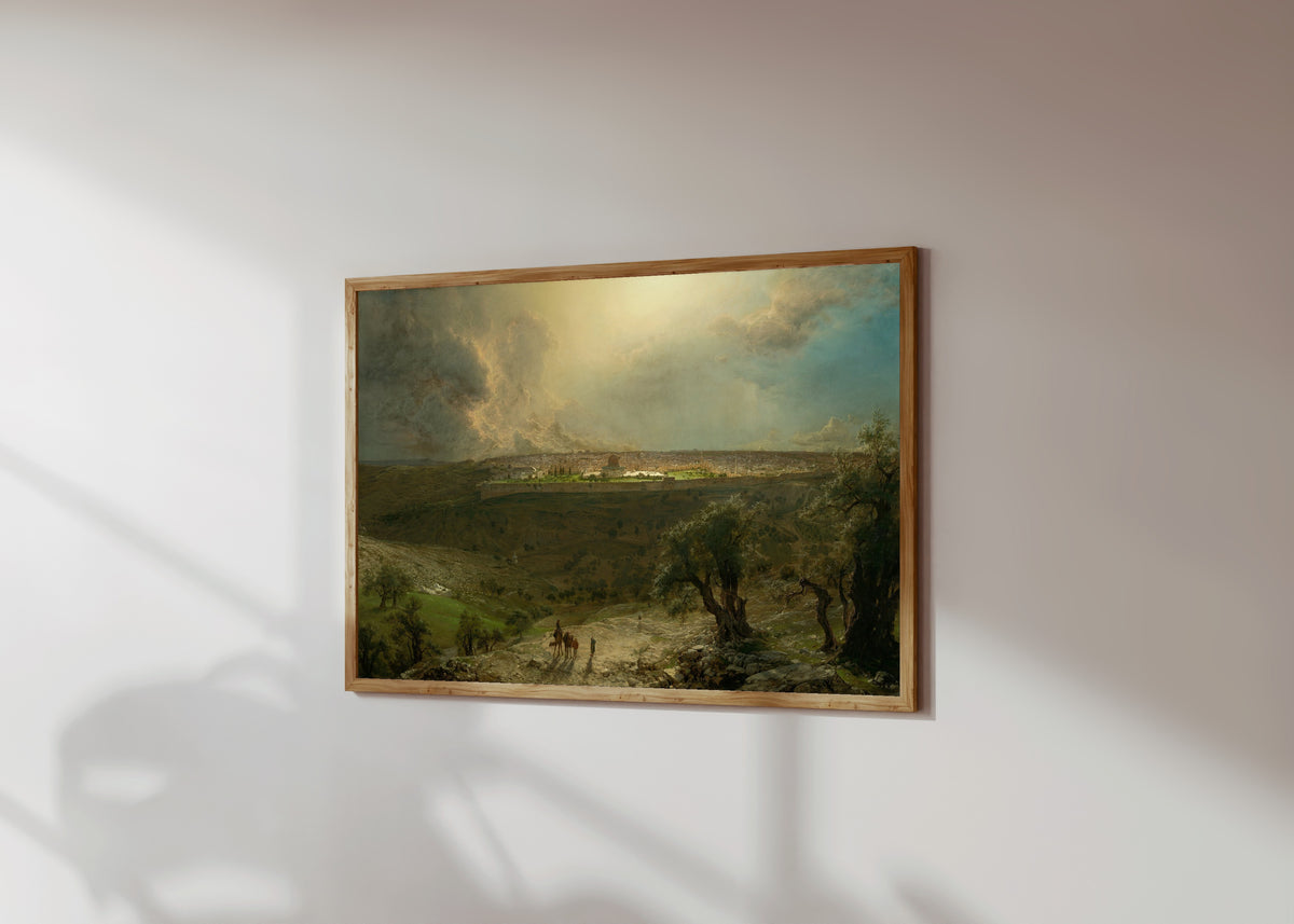 Framed art print of Jerusalem from the Mount of Olives by Albert Bierstadt, in a light wood frame on a sunlit white wall, seen at a slight angle