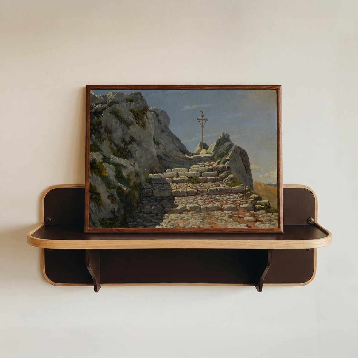 Framed art print of Landscape by Albert Bierstadt, in a dark wood frame resting on a wall shelf