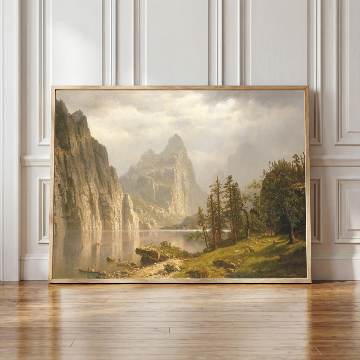 Framed art print of Merced River, Yosemite Valley by Albert Bierstadt, in a light wood frame leaning against a panelled white wall