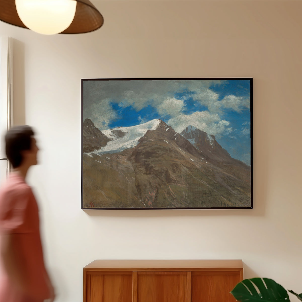 Framed art print of Peaks in the Rockies by Albert Bierstadt, in a slim black frame on a warm wall in a sunlit room