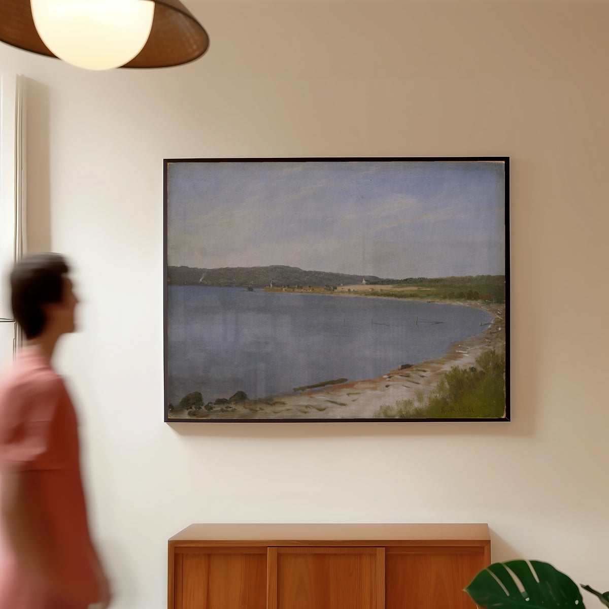 Framed art print of San Francisco Bay by Albert Bierstadt, in a slim black frame on a warm wall in a sunlit room