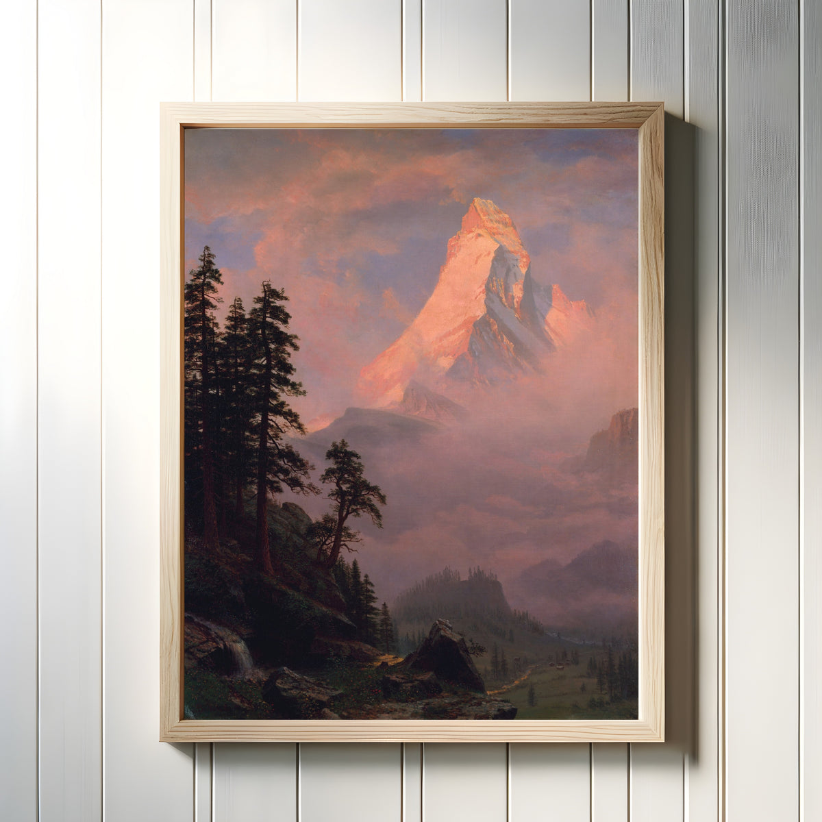Framed art print of Sunrise on the Matterhorn by Albert Bierstadt, in a light wood frame on a white panelled wall