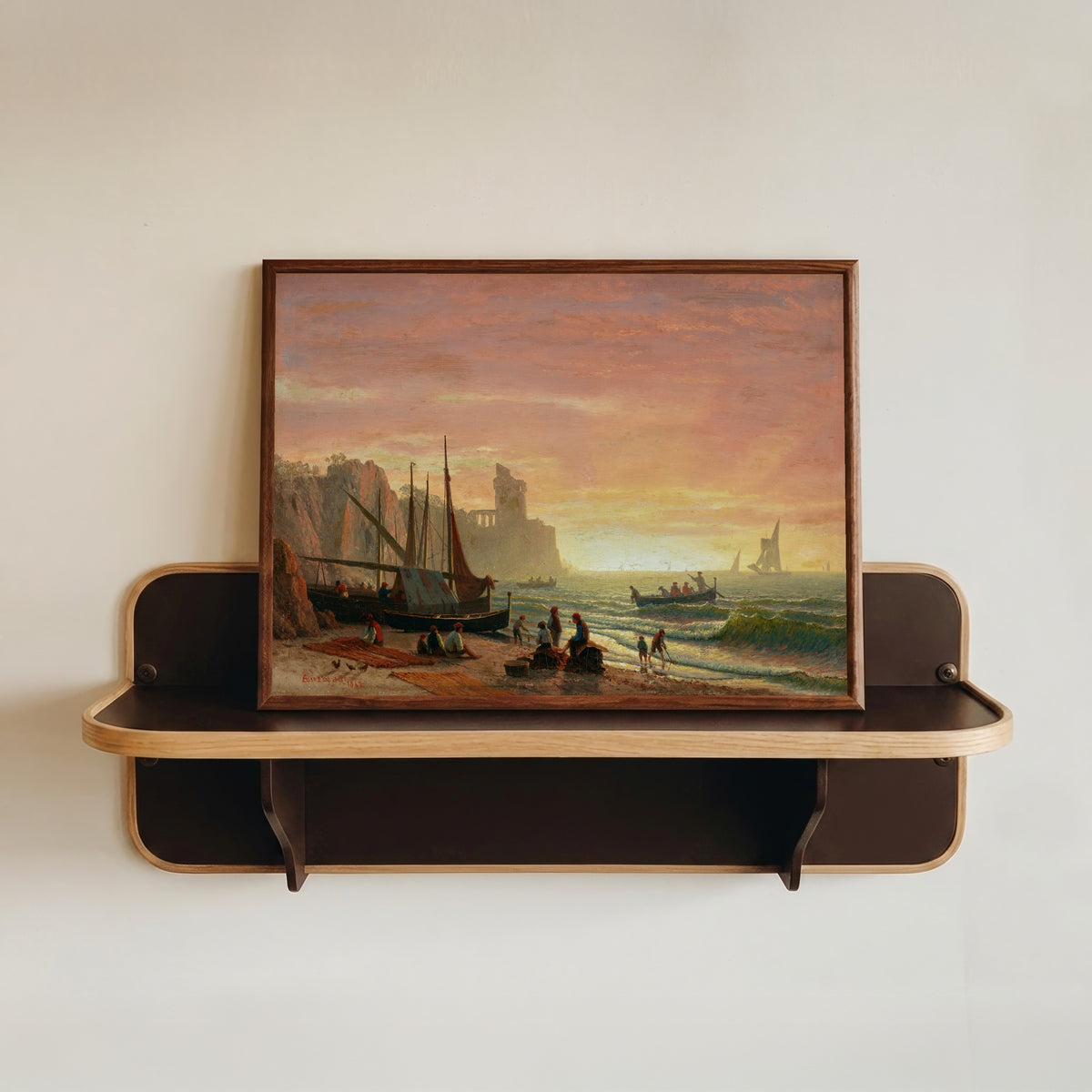 Framed art print of The Fishing Fleet by Albert Bierstadt, in a dark wood frame resting on a wall shelf