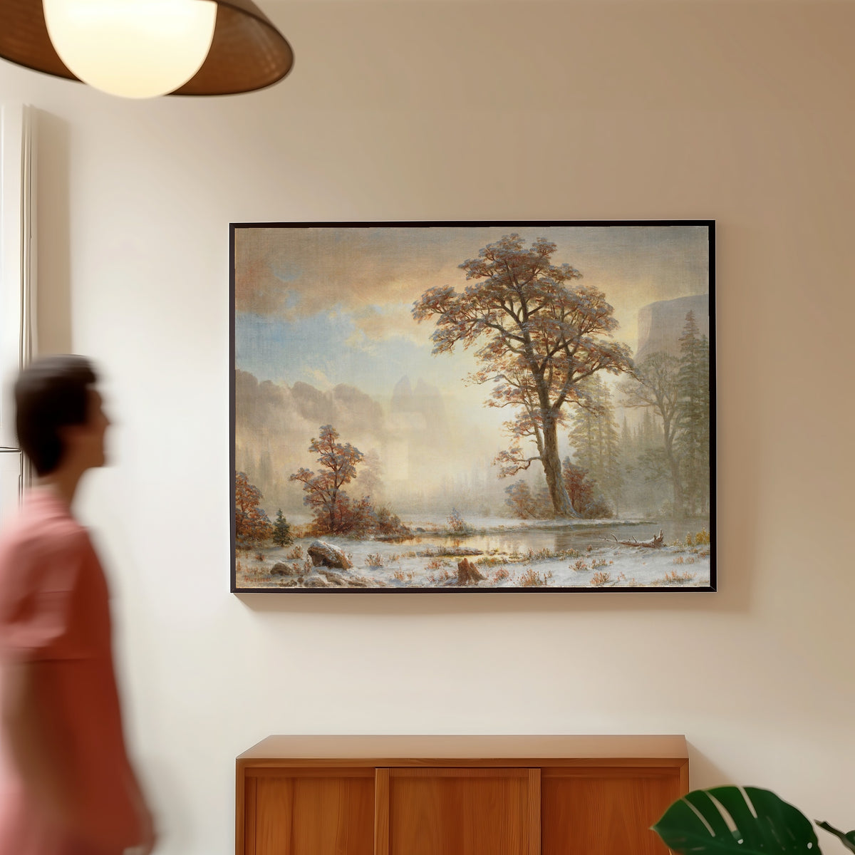 Framed art print of First Snowfall of the Year by Albert Bierstadt, in a slim black frame on a warm wall in a sunlit room