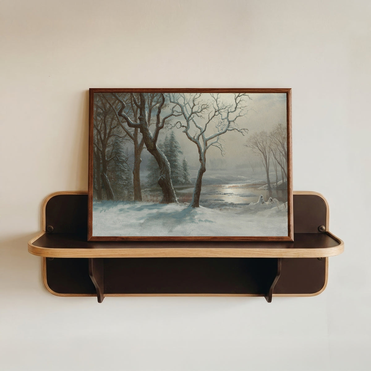 Framed art print of Winter in Yosemite by Albert Bierstadt, in a dark wood frame resting on a wall shelf