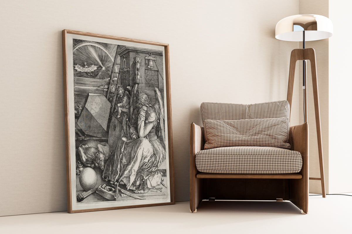 Framed art print of Melencolia I by Albrecht Dürer, leaning against a wall beside an armchair and a floor lamp