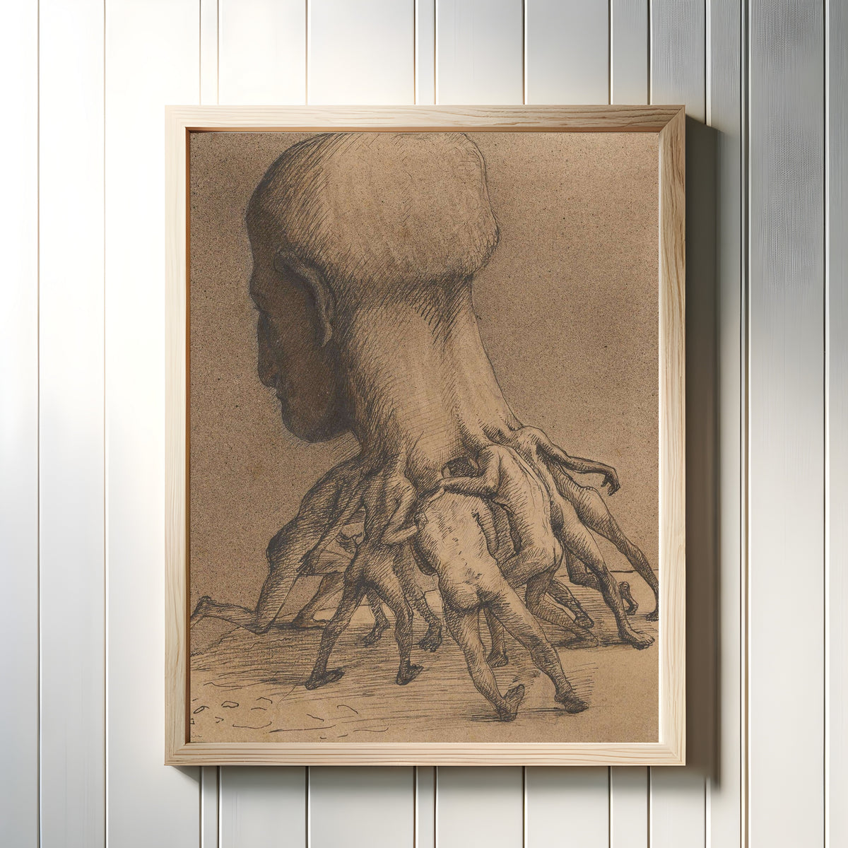 Framed art print of The Great Head by Alfred Kubin, in a light wood frame on a white panelled wall