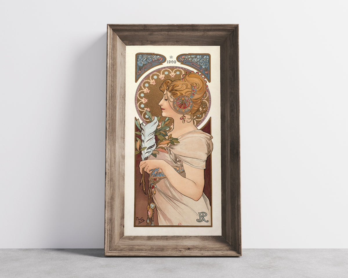 Framed art print of La Plume by Alphonse Mucha, in a wide wooden frame leaning against a concrete wall