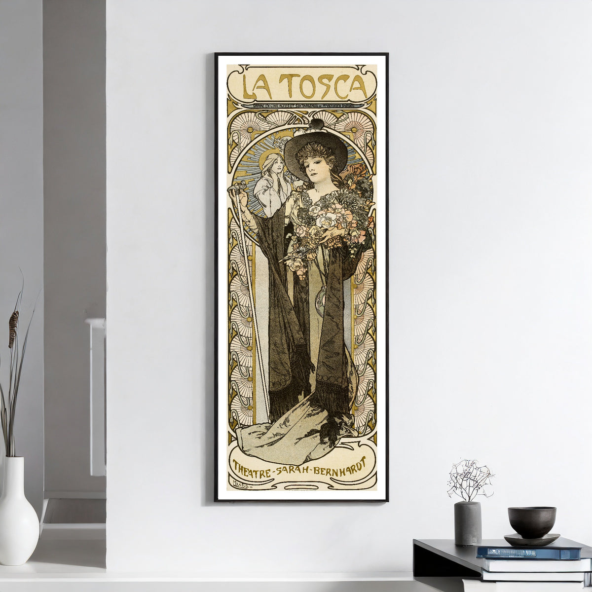 La Tosca by Alphonse Mucha — framed on a white wall above books and a bowl