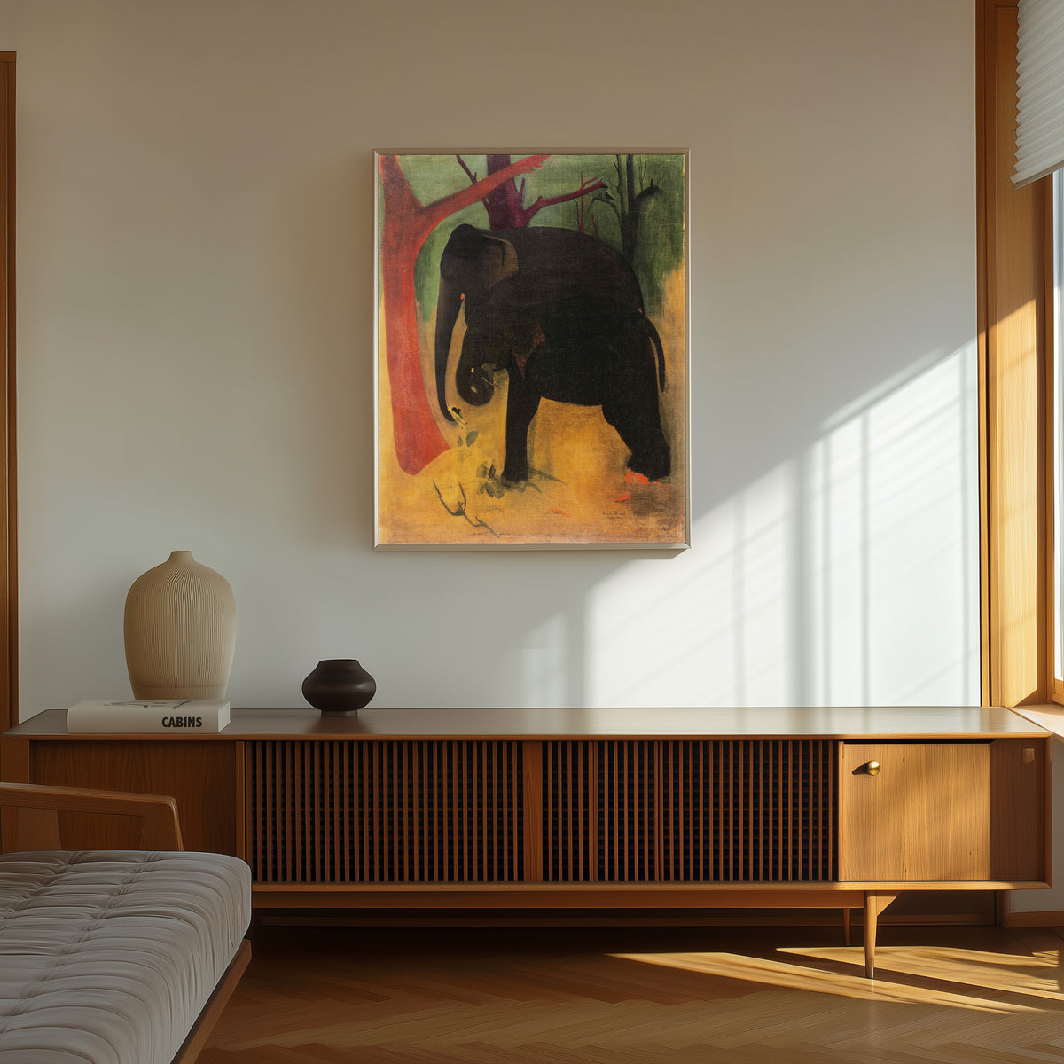 Framed art print of Elephants (1940) by Amrita Sher-Gil, in a thin light frame on a sunlit wall above a wooden sideboard