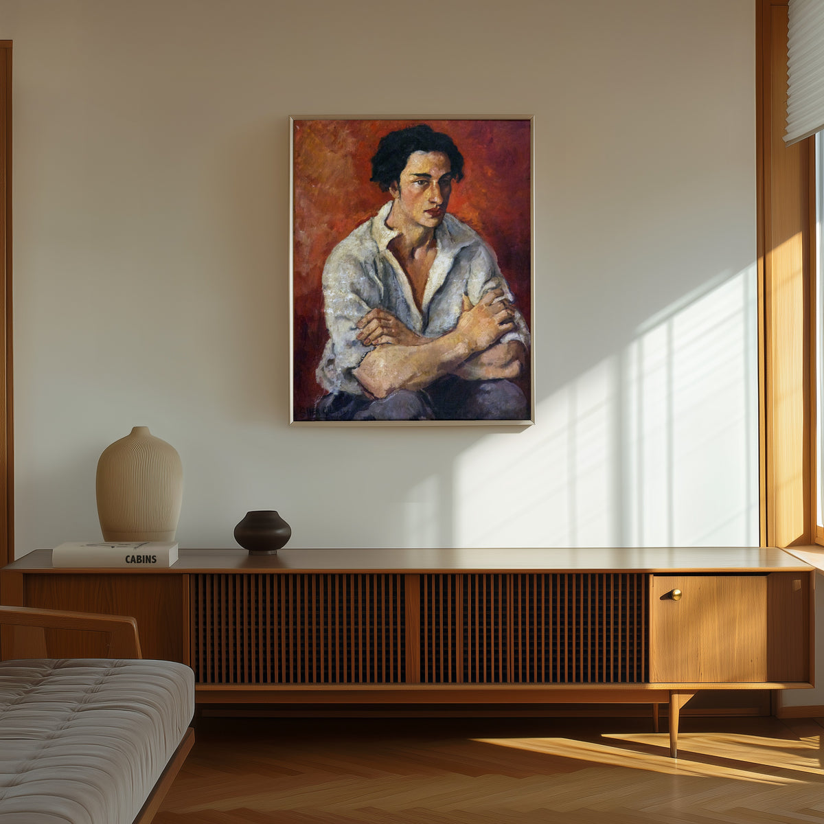 Framed art print of Portrait of a Young Man (1930) by Amrita Sher-Gil, in a thin light frame on a sunlit wall above a wooden sideboard