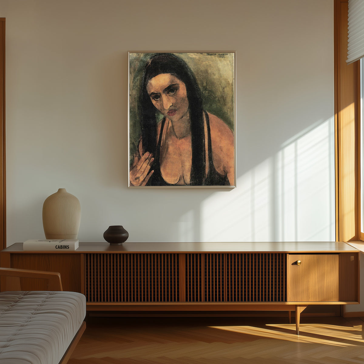 Framed art print of Self-Portrait with Long Hair (1934) by Amrita Sher-Gil, in a thin light frame on a sunlit wall above a wooden sideboard