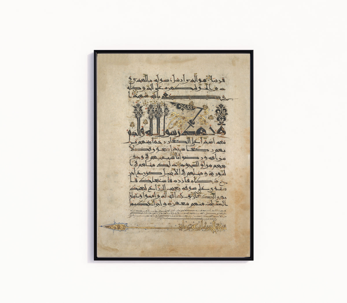 Framed art print of Folios from a Qur'an Manuscript in Floriated "New Style" Script, in a slim black frame on a plain white wall