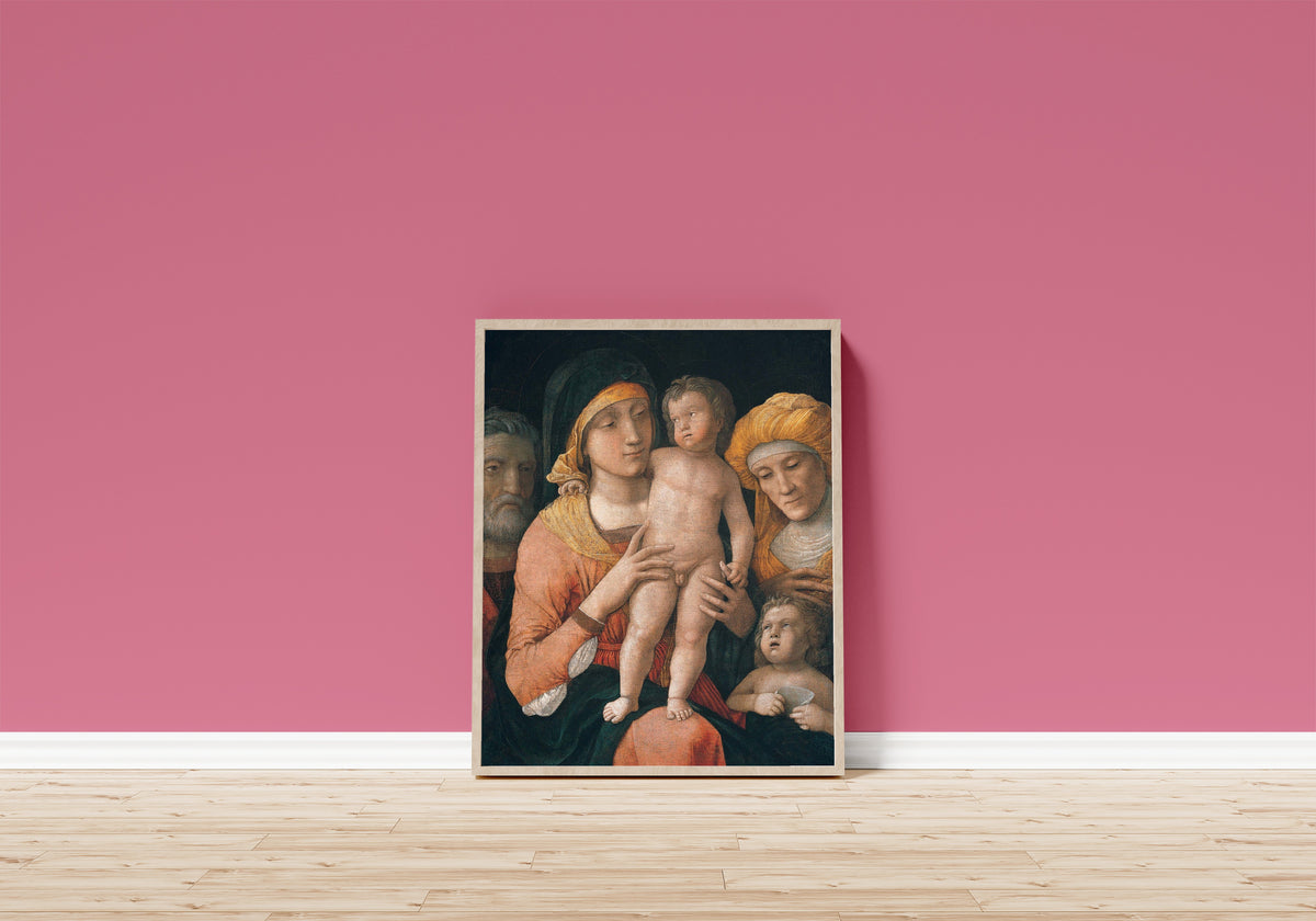 Framed art print of The Madonna and Child with Saints Joseph, Elizabeth… by Andrea Mantegna, in a light wood frame leaning on a pink wall above a wooden floor