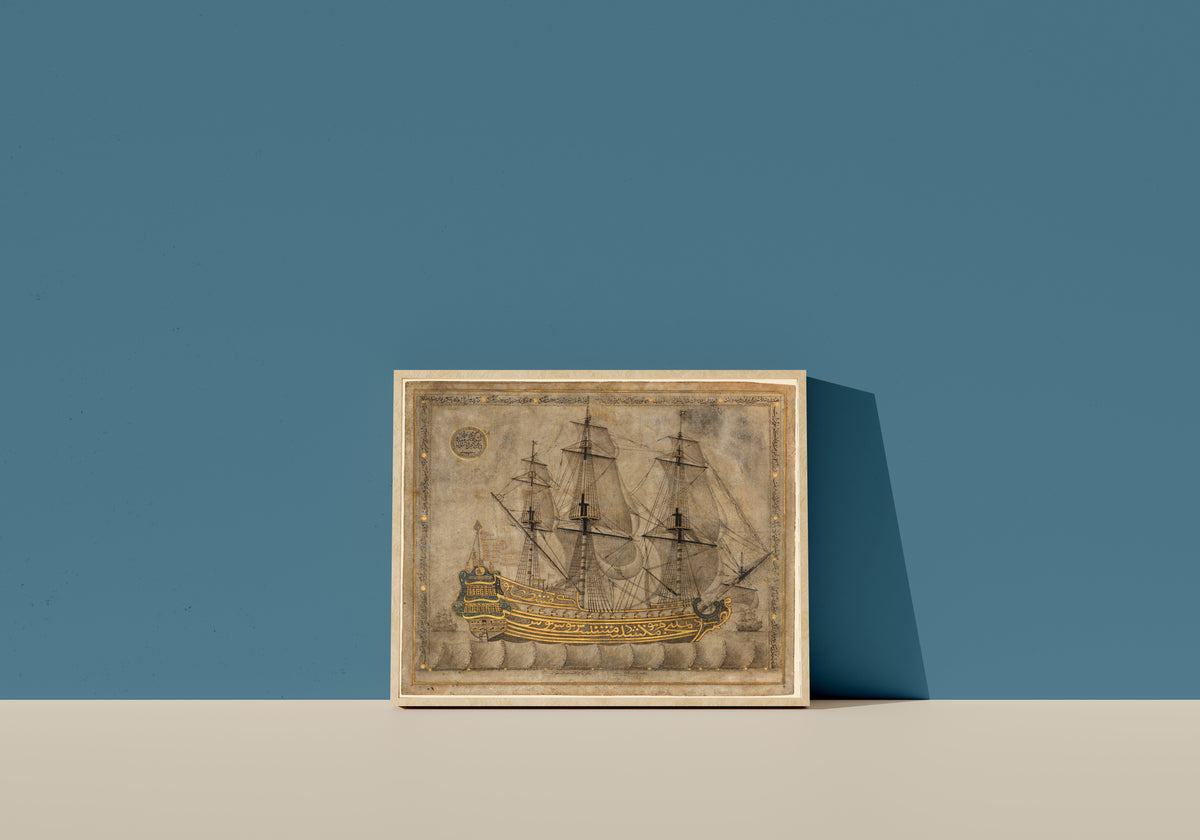 Framed art print of Islamic Calligraphy by 'Abd al-Qadir al-Hisari, in a light wood frame leaning on a blue wall