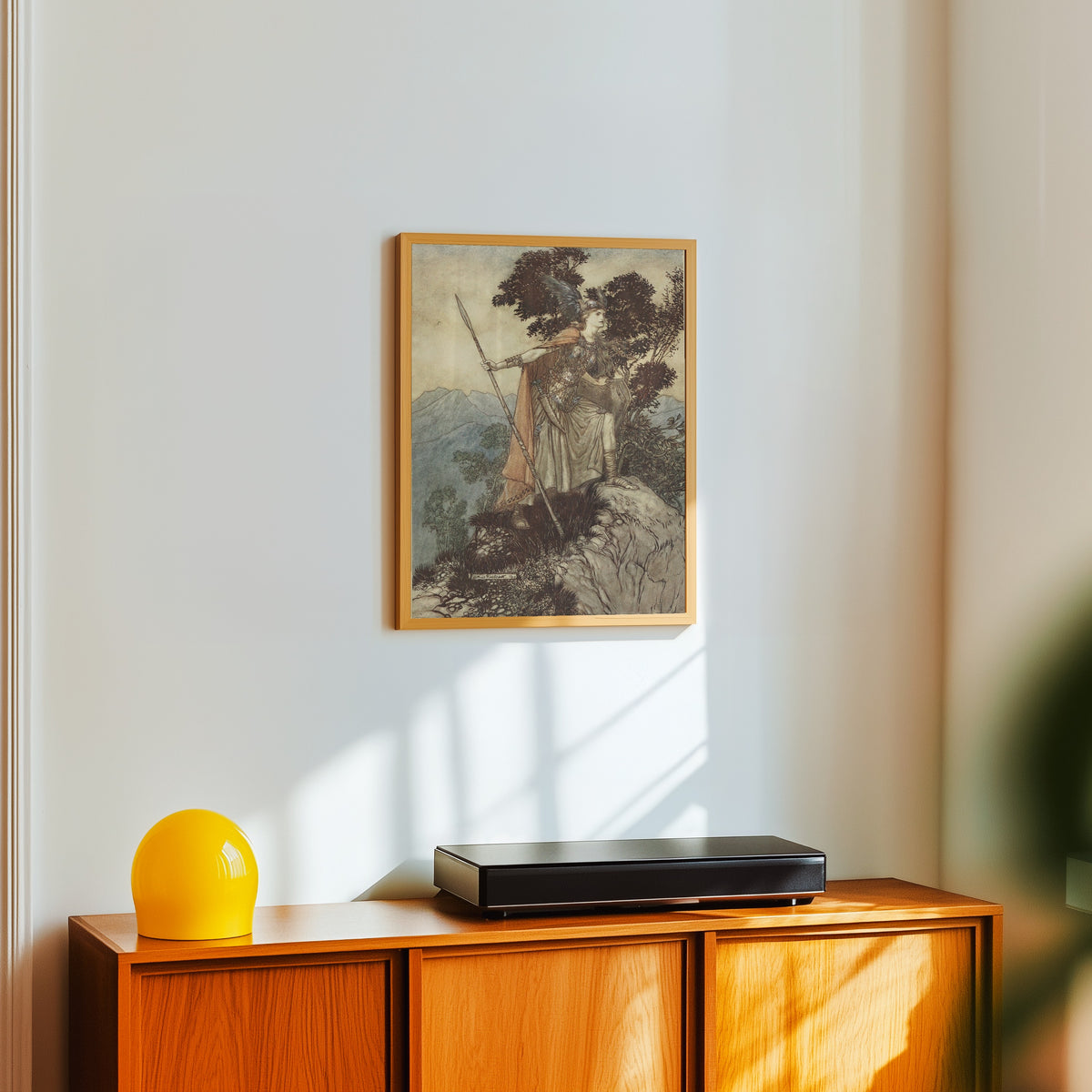 Framed art print of Brünnhilde by Arthur Rackham, in a light wood frame on a white wall above an orange sideboard
