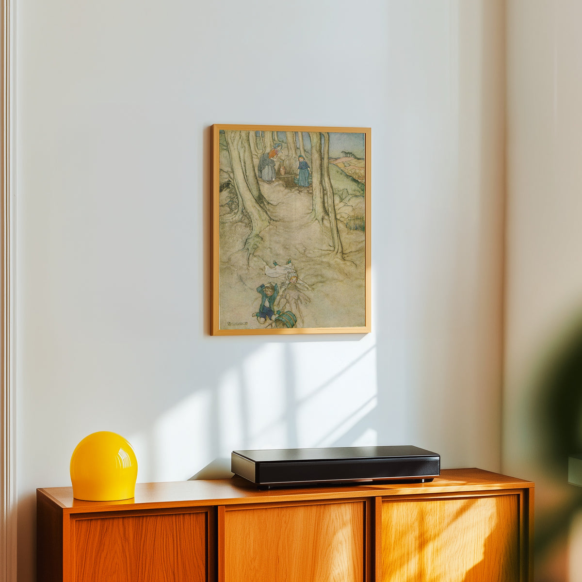 Framed art print of Jack and Jill by Arthur Rackham, in a light wood frame on a white wall above an orange sideboard