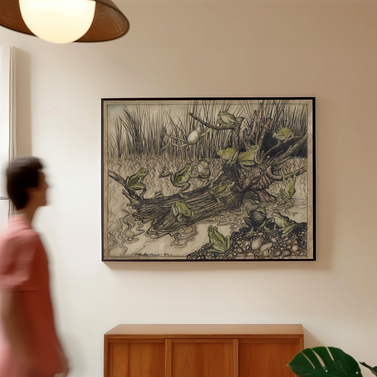 Framed art print of King Log by Arthur Rackham, in a slim black frame on a warm wall in a sunlit room