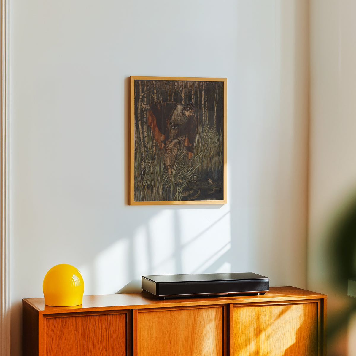 Framed art print of The Fishes, in Their Joy, Stretched Up Their Heads by Arthur Rackham, in a light wood frame on a white wall above an orange sideboard