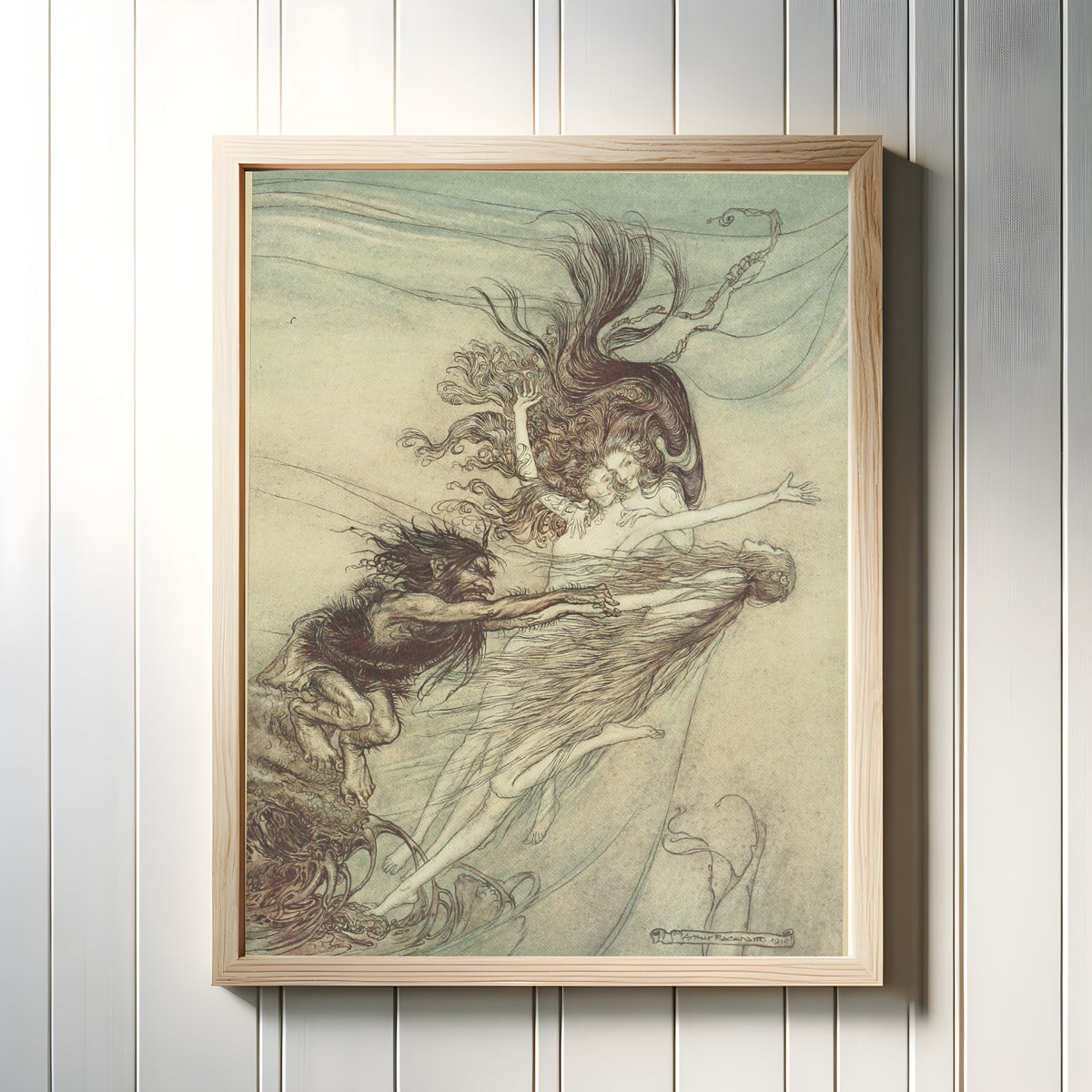 Framed art print of The Rhine-Maidens Teasing Alberich by Arthur Rackham, in a light wood frame on a white panelled wall