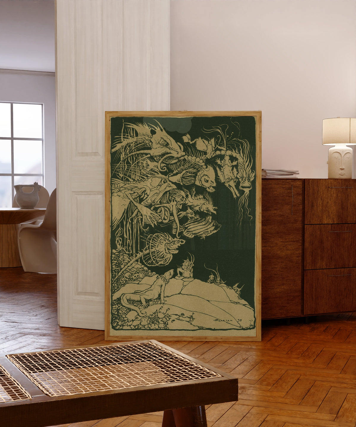 Framed art print of They’d Such Very Odd Heads and Such Very Odd Tails by Arthur Rackham, in a light wood frame leaning in a warm room with a parquet floor