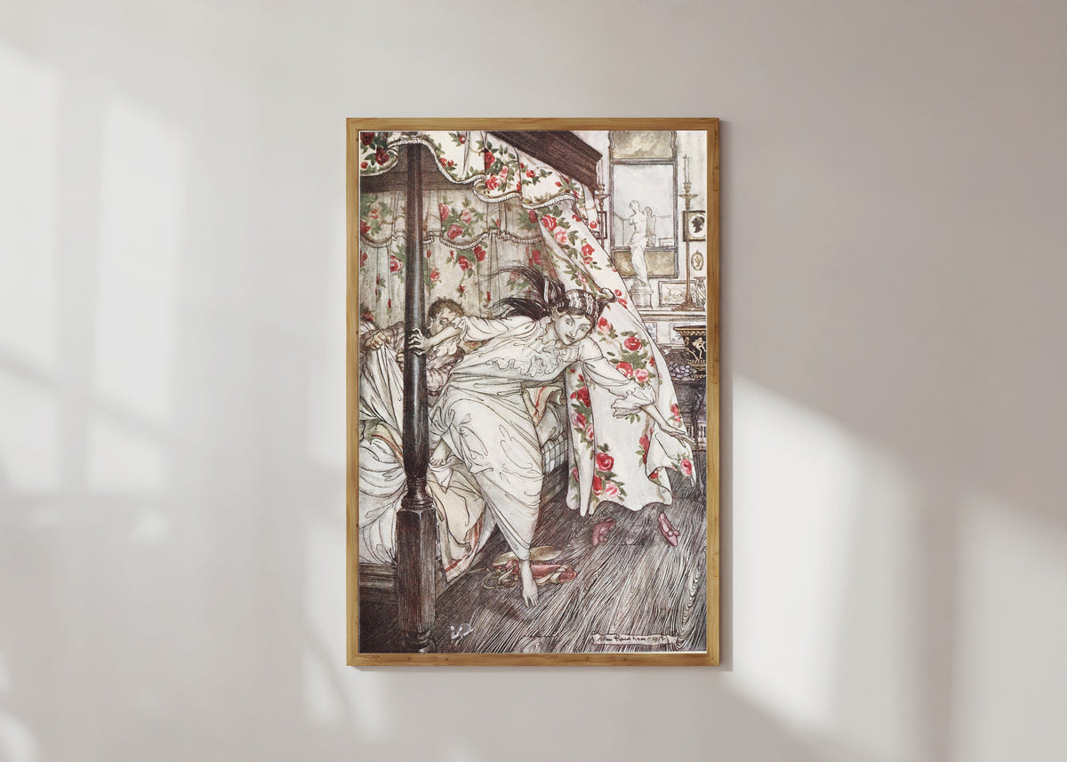 Framed art print of Venus and the Cat by Arthur Rackham, in a light wood frame on a sunlit white wall
