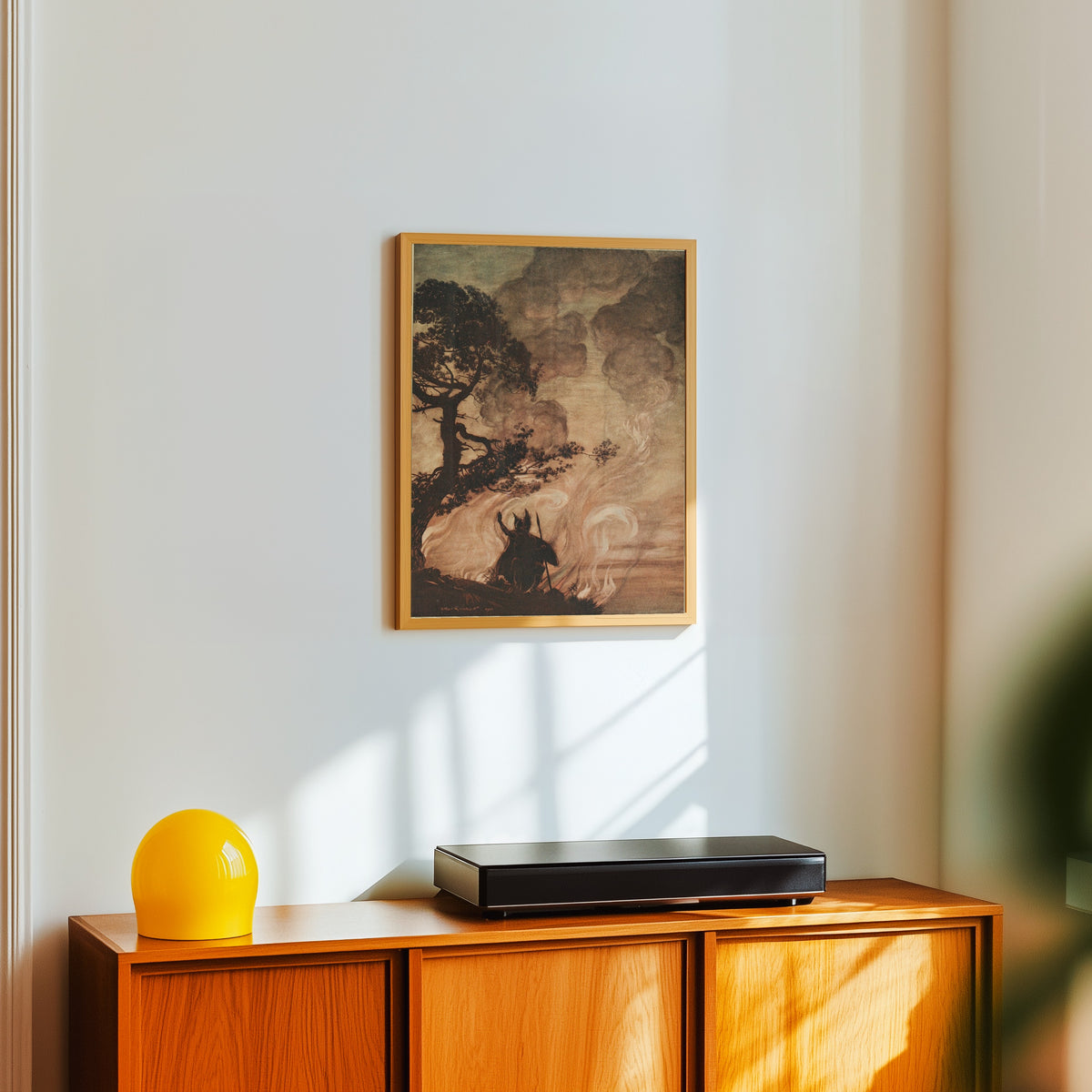 Framed art print of Wotan Turns and Looks Sorrowfully Back at Brünnhilde by Arthur Rackham, in a light wood frame on a white wall above an orange sideboard