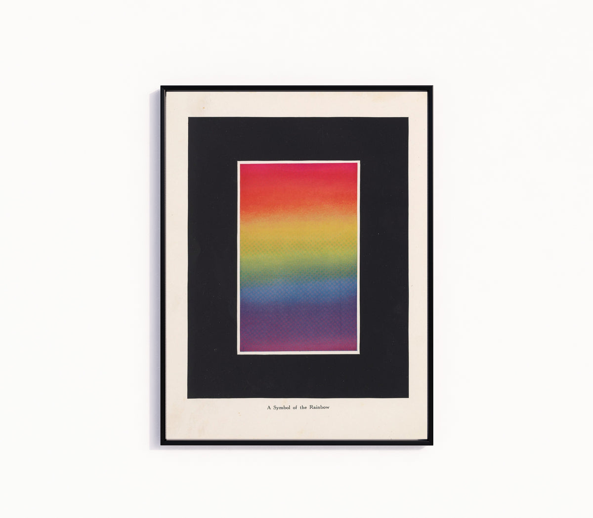 Framed art print of Symbol of the Rainbow by Bonnie E. Snow, in a slim black frame on a plain white wall