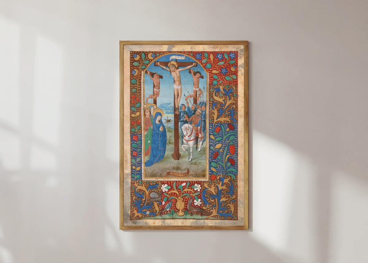 Framed art print of Book of Hours: The Crucifixion, in a light wood frame on a sunlit white wall