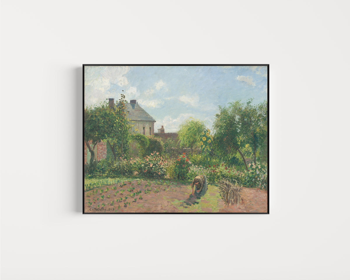 Framed art print of The Artist's Garden at Eragny by Camille Pissarro, in a slim black frame on a plain white wall