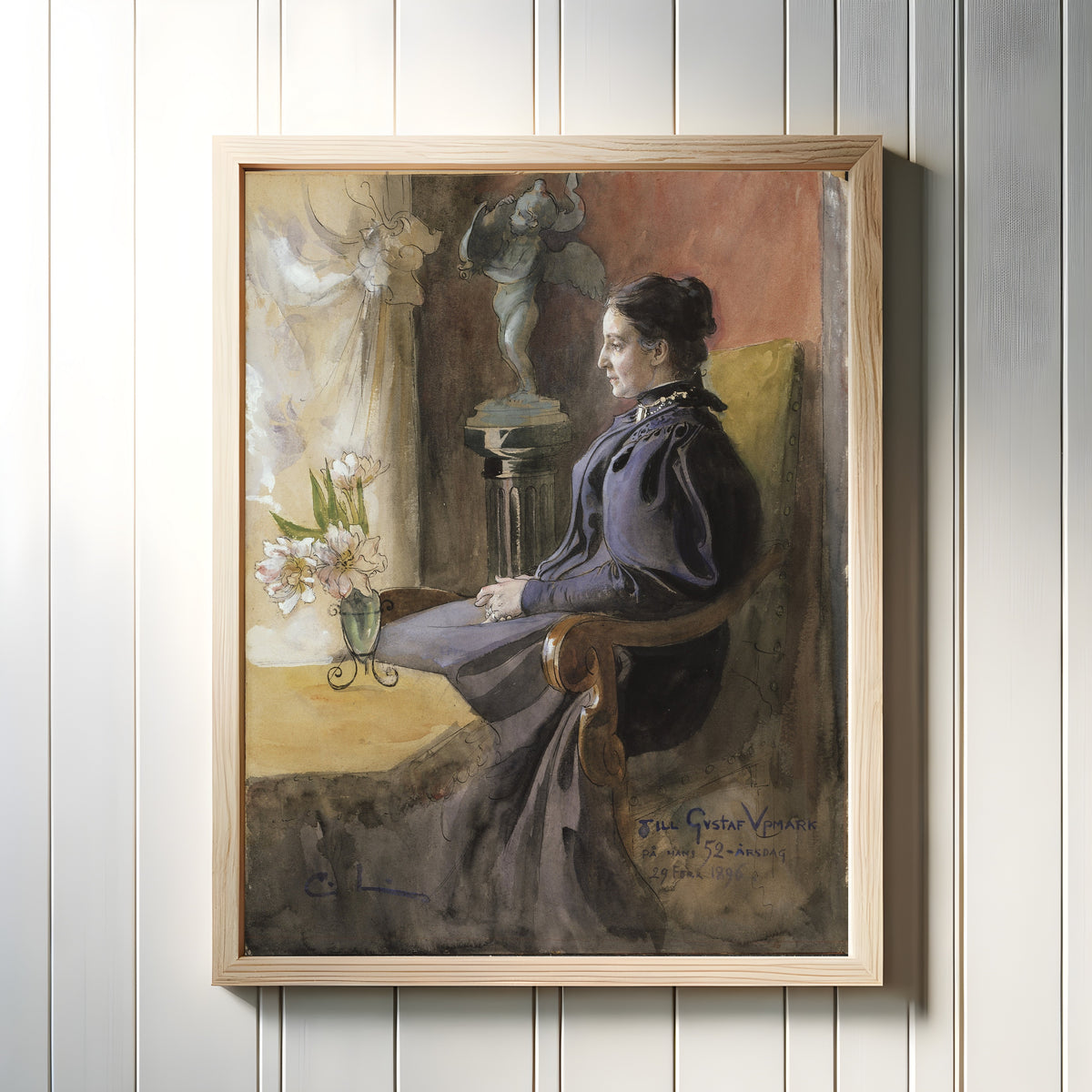 Framed art print of Eva Upmark, née Kindstrand by Carl Larsson, in a light wood frame on a white panelled wall