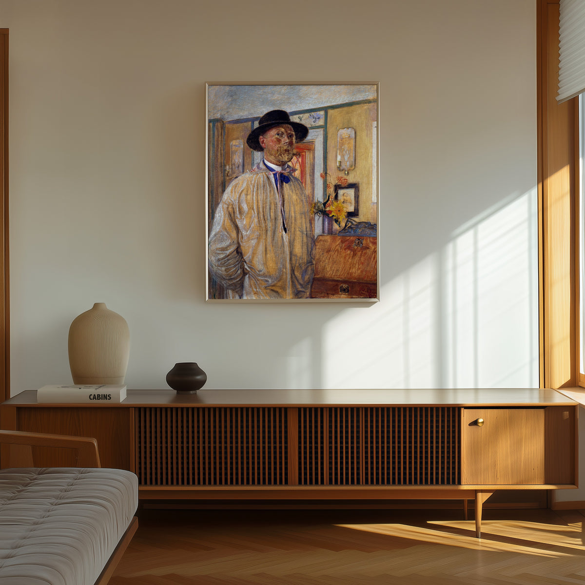 Framed art print of Self-Portrait by Carl Larsson, in a thin light frame on a sunlit wall above a wooden sideboard
