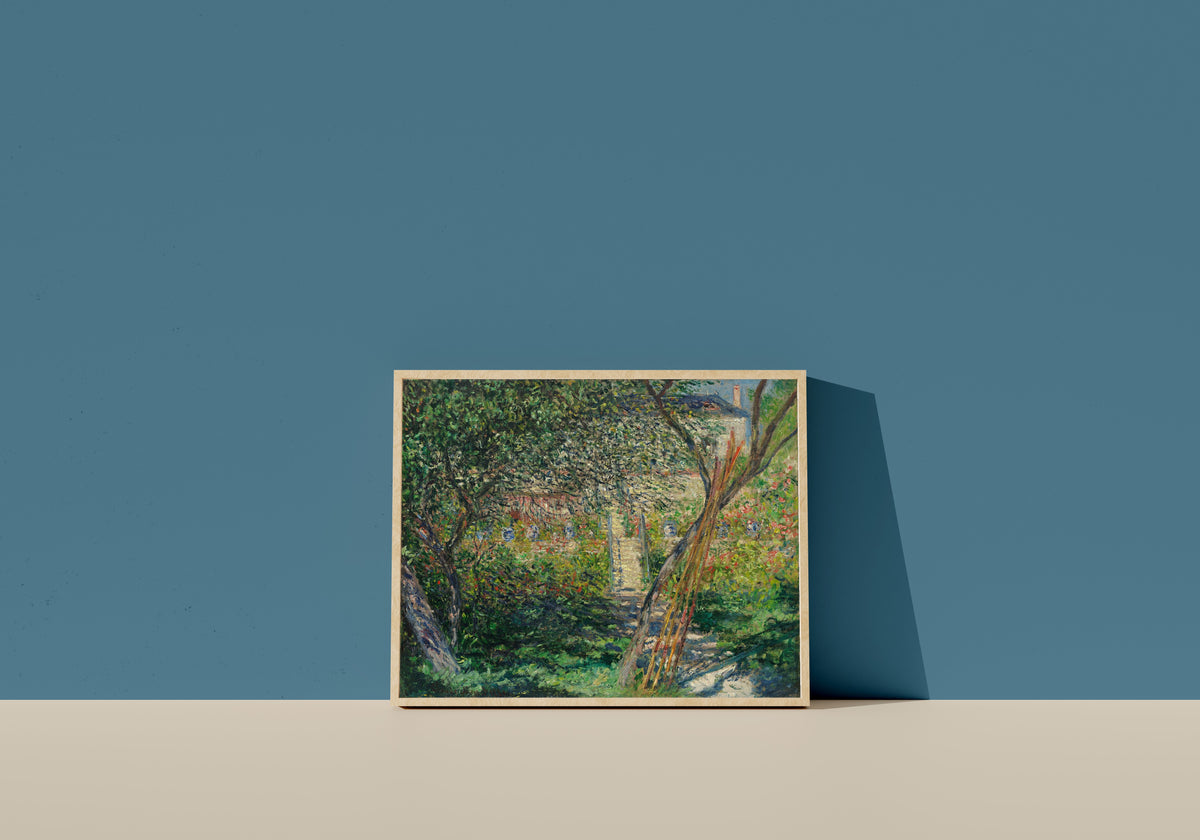 Framed art print of Garden at Vétheuil by Claude Monet, in a light wood frame leaning on a blue wall