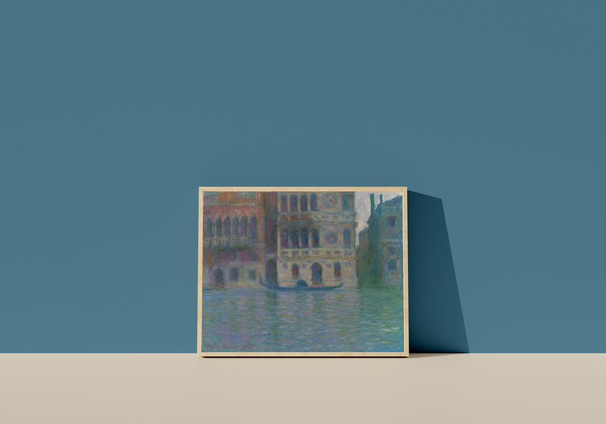 Framed art print of Venice, Palazzo Dario by Claude Monet, in a light wood frame leaning on a blue wall