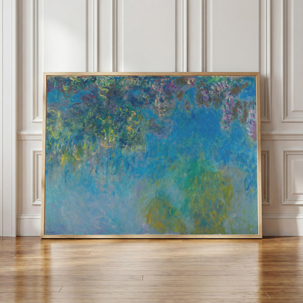 Framed art print of Wisteria by Claude Monet, in a light wood frame leaning against a panelled white wall