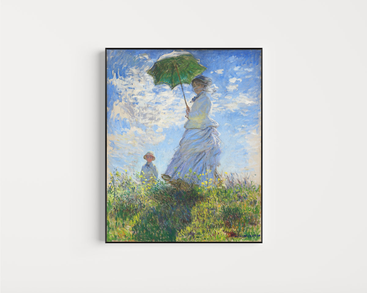 Framed art print of Woman with a Parasol - Madame Monet and Her Son by Claude Monet, in a slim black frame on a plain white wall