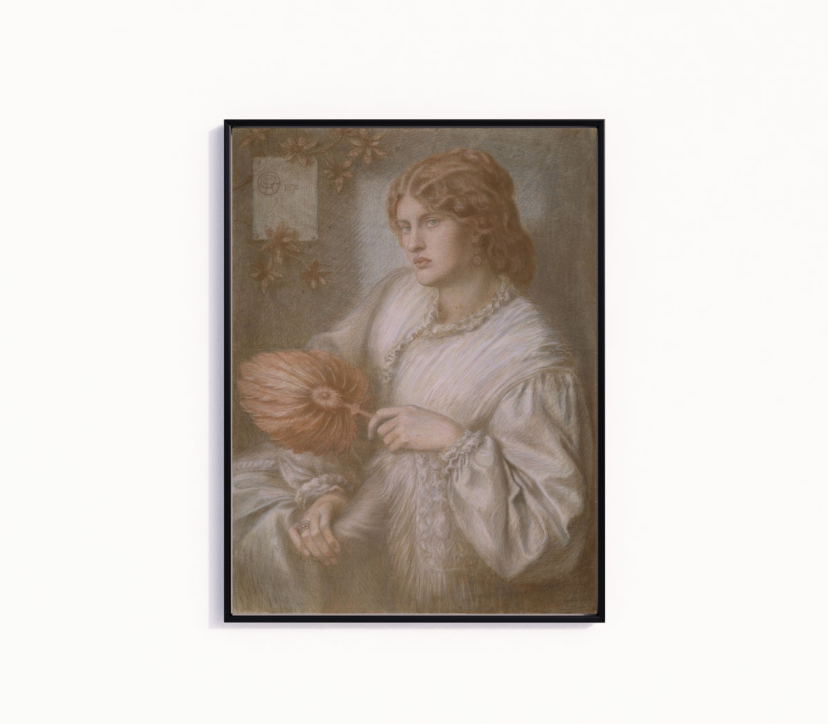 Framed art print of Portrait of Woman with a Fan by Dante Gabriel Rossetti, in a slim black frame on a plain white wall