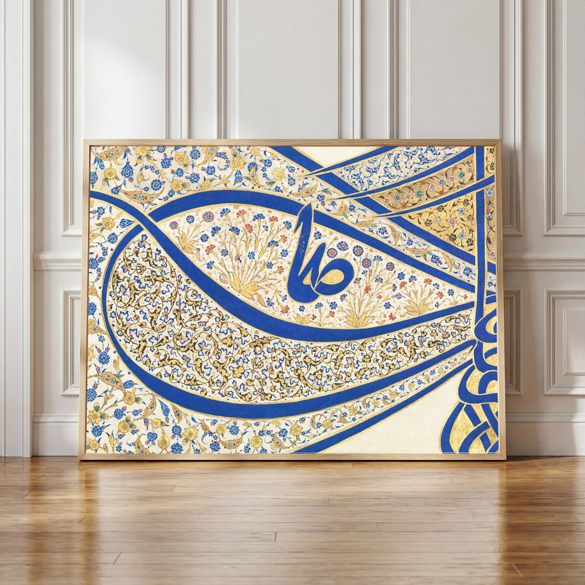Framed art print of Tughra of Sultan Suleiman the Magnificent (16th Ct. Detail) by Sultan Suleiman, in a light wood frame leaning against a panelled white wall