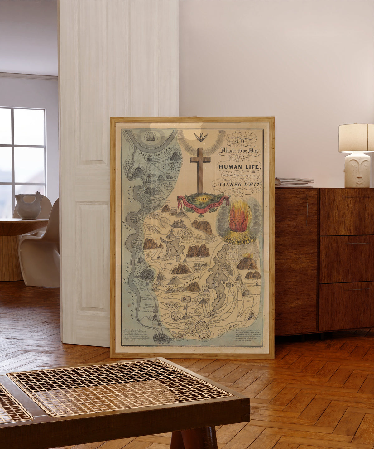 Framed art print of An Illustrative Map of Human Life Deduced from… by E.B. & E.C. Kellogg, in a light wood frame leaning in a warm room with a parquet floor
