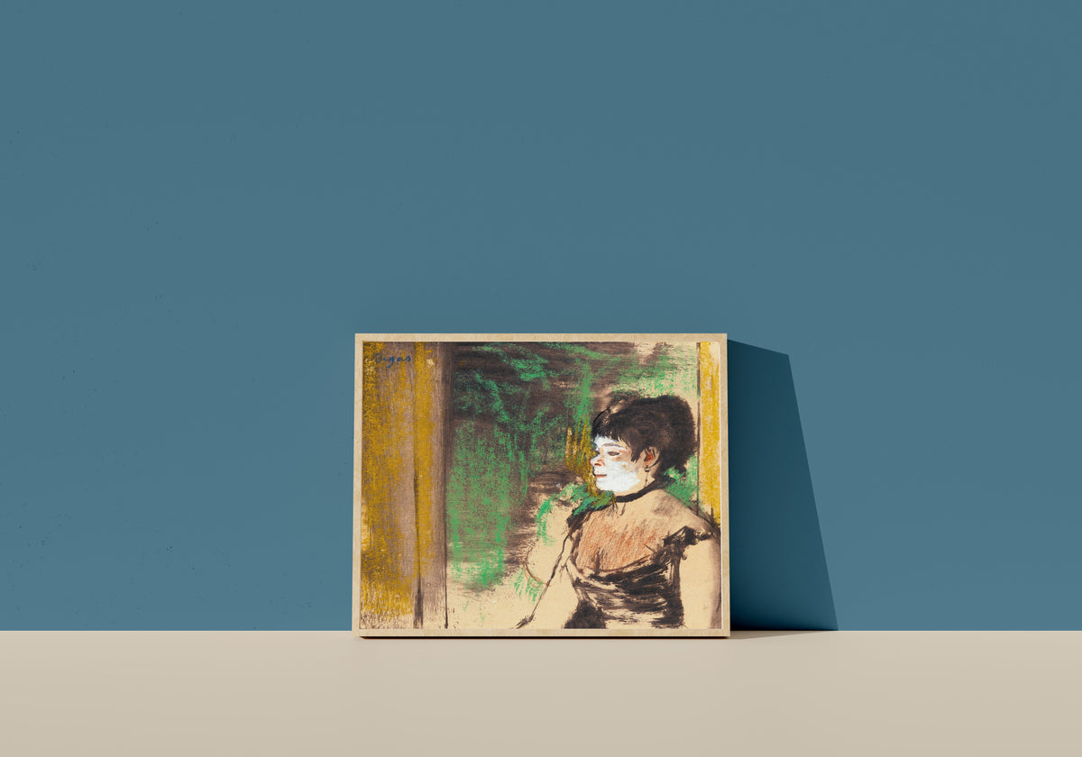 Framed art print of Chanteuse de café-concert by Edgar Degas, in a light wood frame leaning on a blue wall