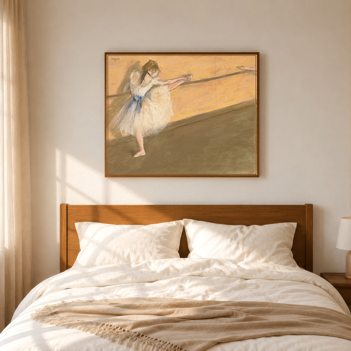 Framed art print of Dancer at the Barre (Orange Wall) by Edgar Degas, in a slim wood frame above a bed in a sunlit bedroom