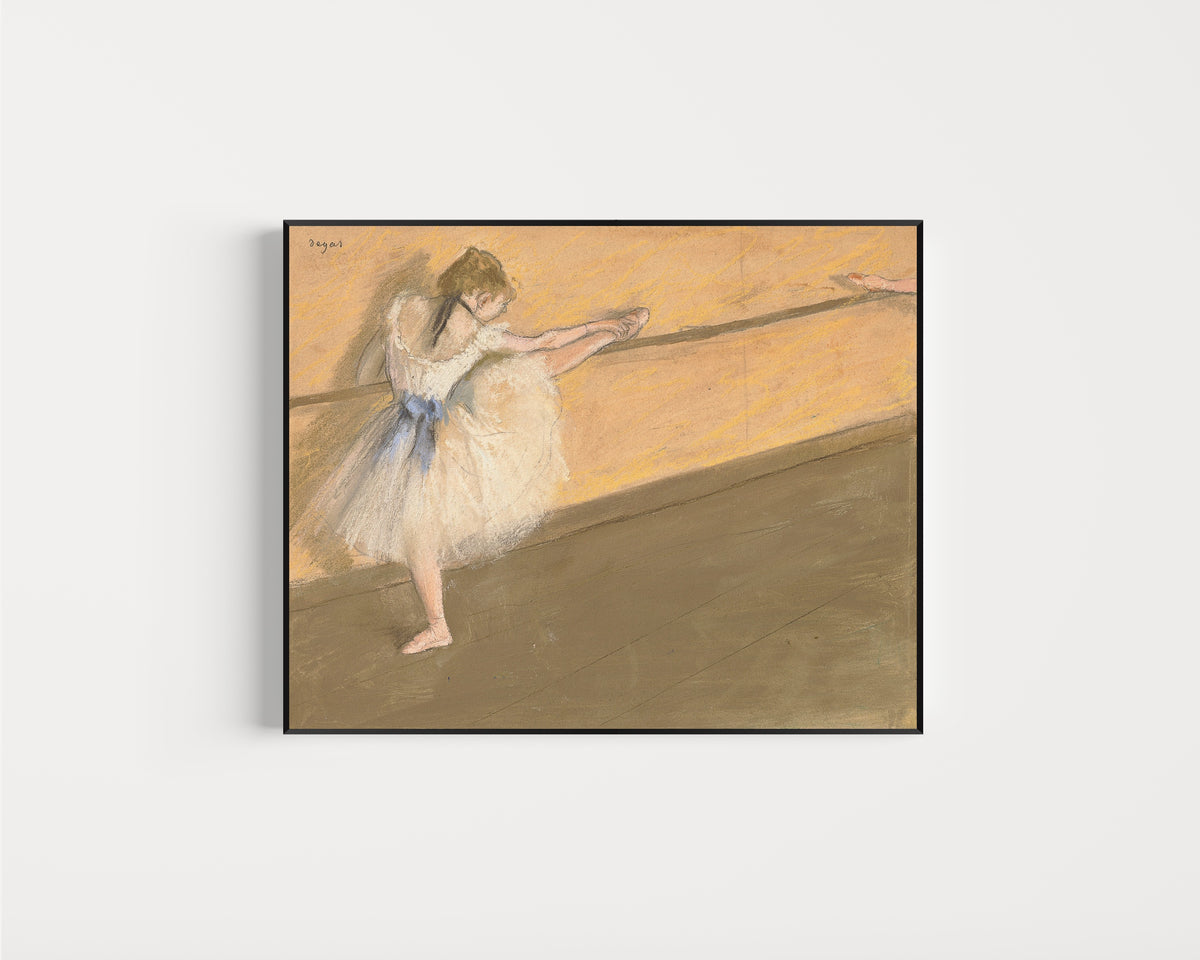 Framed art print of Dancer at the Barre (Orange Wall) by Edgar Degas, in a slim black frame on a plain white wall