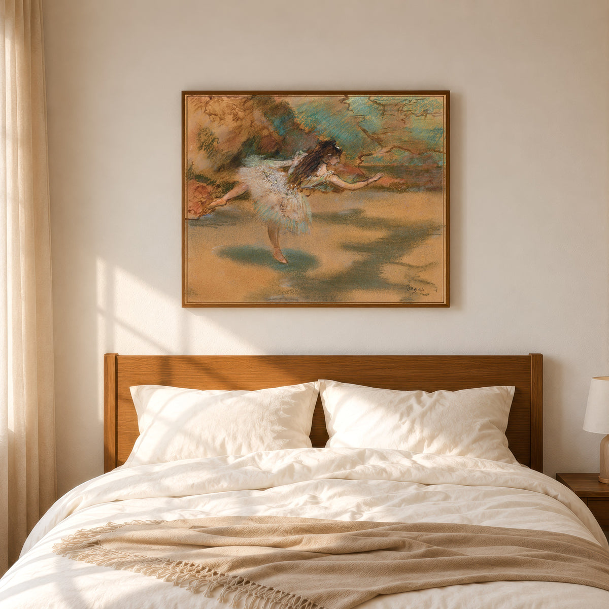Framed art print of Dancer on Pointe by Edgar Degas, in a slim wood frame above a bed in a sunlit bedroom