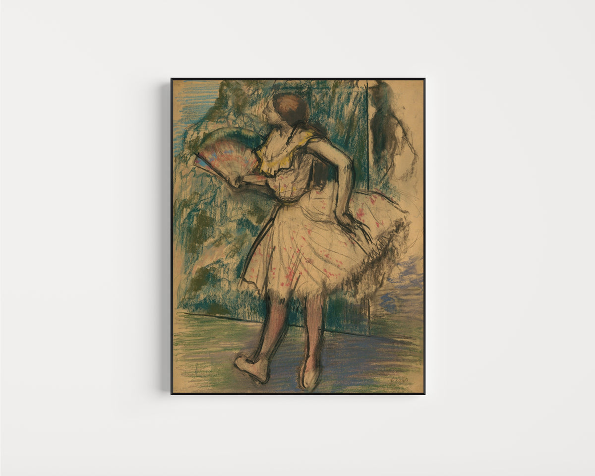 Framed art print of Dancer with a Fan by Edgar Degas, in a slim black frame on a plain white wall
