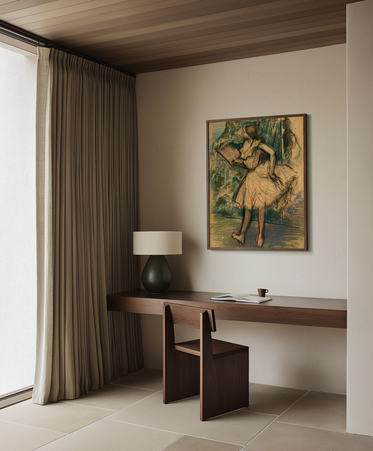 Framed art print of Dancer with a Fan by Edgar Degas, in a dark wood frame on a plaster wall above a walnut desk